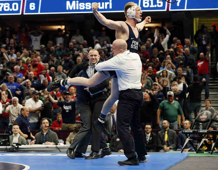 Penn State’s Bo Nickel celebrates by jumping into the arms of coach Cael Sanderson after pinning Ohio State’s Myles Martin (184) in the 184 finals and winning the team title during the 2018 NCAA Division I Wrestling Championships at Quicken Loans Arena in Cleveland.    (Kyle Robertson / The Columbus Dispatch)